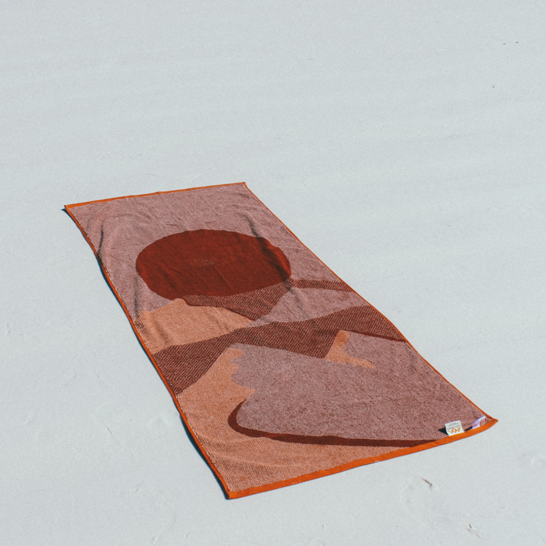 The reverse (back) side of The Dunes Beach Towel. It is lying down on a white sandy beach